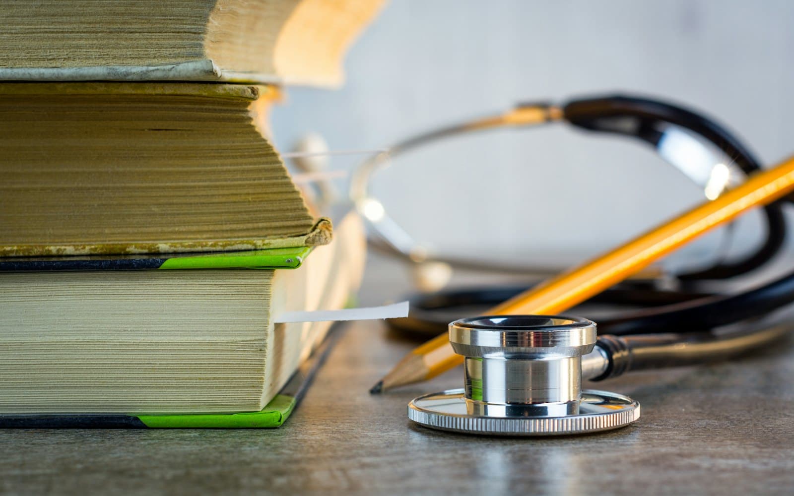 A stethoscope resting beside a stack of old reference books