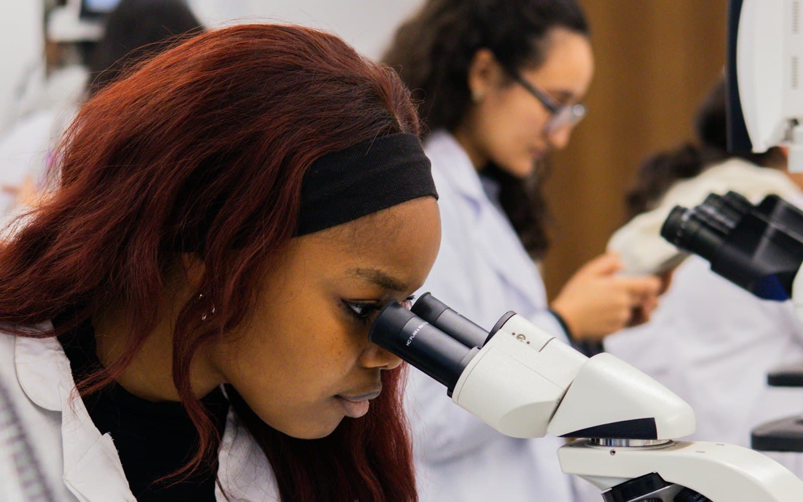 A student looking through a microscope in a teaching lab